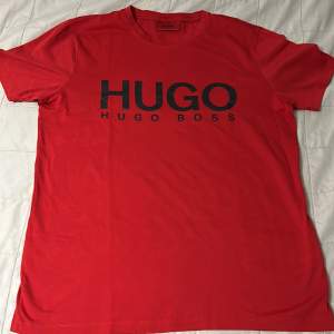 En röd Hugo Boss tshirt i storlek XS men passar även S. 