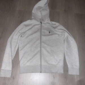 Polo Ralph lauren - Säljer en Grå Ralph lauren hoddie har tagit bort snören bra skick använd fåtal gånger 8/10 Storlek S hör av dig om har några frågor eller funderingar! Pris kan diskuteras såklart!