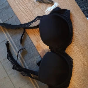 Lingadore bh - Svart oanvänd bygelbh. Går att ha med axelbanden på flera olika vis samt medföljer dessutom extra.