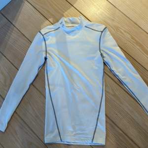 Under Armour compression shirt som kan användas på gymmet eller som underställ. Fint skick och skön. Kom pm vid frågor  