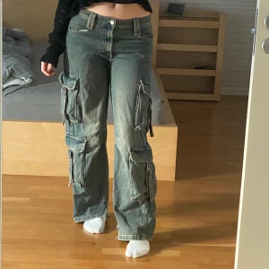 Coola cargobyxor 😎 - Bra skick förutom att de är klippta vid benöppningen på båda sidor för att jag ville att de skulle vara mer baggy nertill. Märks inte av när man har på sig de. Annars bra skick. Har klamror där bak så man kan justera storleken 