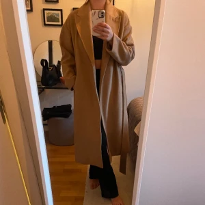 Beige kappa Gina Tricot - Jättefin beige kappa från Gina Tricot. Storlek 38, använt men bra skick. 50% ull.