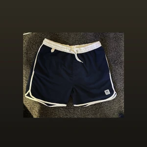 Badshorts (herr) - Mörkblåa badbyxor från ellos. Strl M (herr) 2 fickor fram och 1 bak. 