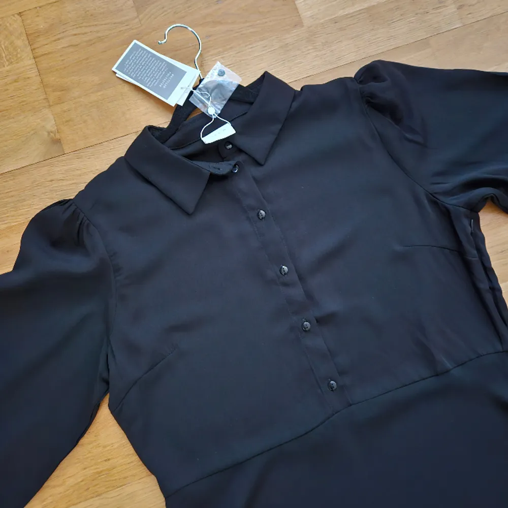 Ej använd, bara provad, nyskick. Fin  skjortklänning med knappar från midjan och upp. Material: polyester  Prislapp sitter kvar, nypris 449.90 kr.. Klänningar.