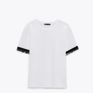 Vit t-shirt med svarta detaljer - Vit t-shirt med svarta detaljer i ärmarna från Zara🖤 Använd endast en gång så väldigt bra skick!