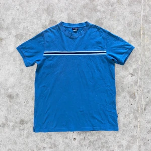 Vintage blå t-shirt - Cool unik 90s vintage t-shirt!!! Riktigt ball till ett par baggy jeans. I fint skick. Av grövre bomull. Går ej att läsa av någon storlek på lappen men estimerar storleken som L. För mått kontakta mig 💛