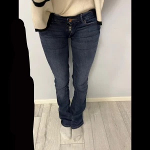 Superlågmidjade bootcut jeans  - Snygga blå jeans med bootcut-stil och jättelågmidja. Har sytt upp så de är jättelågmidjade, vilket även har gjort att de är lite långa. Därav priset, annars inga defekter, men lite slitnigar som man ser på sista bilden. Inget fel på gylfen bara att byxorna är för små på mig!