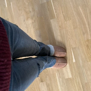 Svarta jeans med slitningar - Jeansen är stor i storleken så jag  som  är 162 cm passar de perfekt.Snygga svart grå jeans med slitningar på knäna. De har en tight passform och är perfekta för en avslappnad stil. Jeansen har skit snygga fickor. Men en av klapparna har ramblat av.
