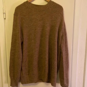 Beige stickad tröja från Mango - Säljer en stilren beige stickad tröja från Mango. Perfekt för kyligare dagar med sin mjuka och bekväma passform. Tröjan har långa ärmar och en klassisk rund halsringning. Ett måste i garderoben för en avslappnad look.