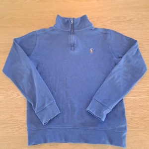 Blå tröja med dragkedja från Ralph Lauren - Säljer en stilren blå tröja från Ralph Lauren med halv dragkedja och broderad logotyp på bröstet. Perfekt för en avslappnad men snygg look. Tröjan har långa ärmar och en bekväm passform. Skick 7/10. DEN ÄR M I BARN STORLEK. Tveka inte på att ställa frågorna 