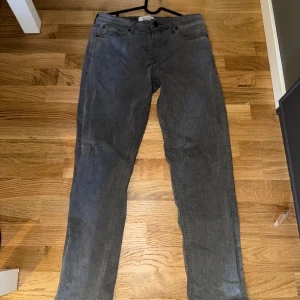 Grå jeansbyxor - Snygga grå jeansbyxor med klassisk femficksdesign. De har en rak passform och är perfekta för en avslappnad stil. Byxorna har en knapp och dragkedja framtill. Strl W30 L32