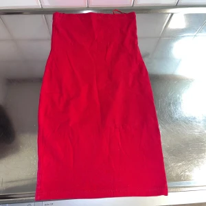 Röd kjol från Gina Tricot - Snygg röd kjol från Gina Tricot i storlek XS. Kjolen har en enkel och stilren design, perfekt för att skapa en färgstark look. Tillverkad i ett mjukt och bekvämt material.