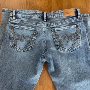 Blå bootcut jeans från Wrangler - Snygga blå bootcut jeans från Gina tricot i nytt skick, har prislappen kvar💕Ett par nya kostar 499 kr så jag säljer mina för 199