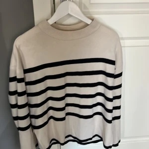 Randig tröja i beige och svart - Stickad tröja från vero Moda i bra skick. Storlek L men passar även S-M