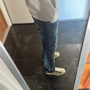 Mörkblå jeans från Nudie Jeans - Säljer ett par mörkblå jeans från Nudie Jeans i modellen Low Slim Jim.  tillverkade i 100%,  snygg slim passform.