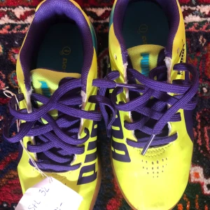 Gula och lila sneakers från Puma - Snygga gula sneakers från Puma med lila snörning och detaljer. Perfekta för en färgglad stil. Skorna har en sportig design med en bekväm passform.