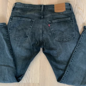 Svarta jeans från Levi's - Snygga svarta jeans från Levi's med klassisk femficksdesign och knappgylf. Perfekta för en avslappnad stil. Märkeslappen i läder baktill ger en autentisk touch.