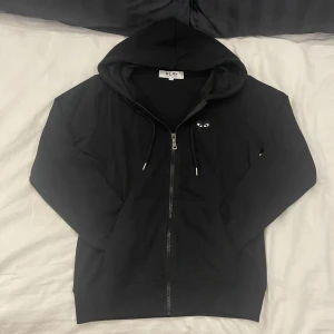 Cdg Zip-hoodie - En riktig snygg Zip-hoodie från Comme des Garçons. | Skicket är 10/10. Men det tål att nämnas att den relativt tun men funkar fortfarande bra som ett extra lager för att hålla värmen. | Det är bara att höra av sig om man har några frågor eller vill ha flera bilder🎉🎉🎉