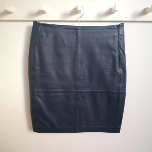 Blå skinnkjol från 2ndday - Blå skinnkjol  från 2ndday modell Cecilia. Storlek 38, nyskick, använd 2 tillfällen. Kjolen är 53 cm lång. Nypris 2700 kr.