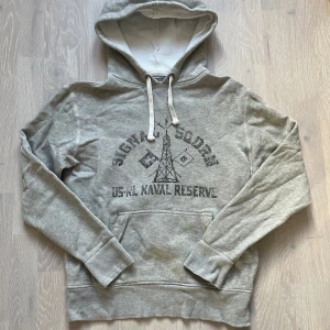 Grå hoodie från Polo Ralph Lauren - Säljer en riktigt fet grå hoodie från Polo Ralph Lauren med unikt tryck och även i väldigt bra skick