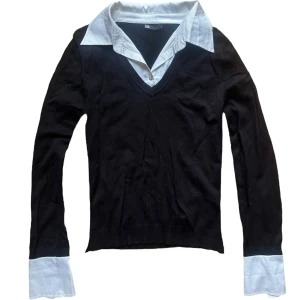Svart vintage tröja med vit krage från Flash - Snygg svart tröja från Flash med vit krage och manschetter. Tröjan har en v-ringad design och långa ärmar. 