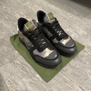 Valentino Rockrunner i camouflage - Snygga Valentino Rockrunner sneakers i ett coolt camouflage-mönster. Skorna har svarta snören och detaljer i skinn och mocka. Perfekta för en stilren och trendig look. Box och dusbag ingår, självklart äkta. För fler bilder eller frågor kom privat. Priset ej hugget i sten!