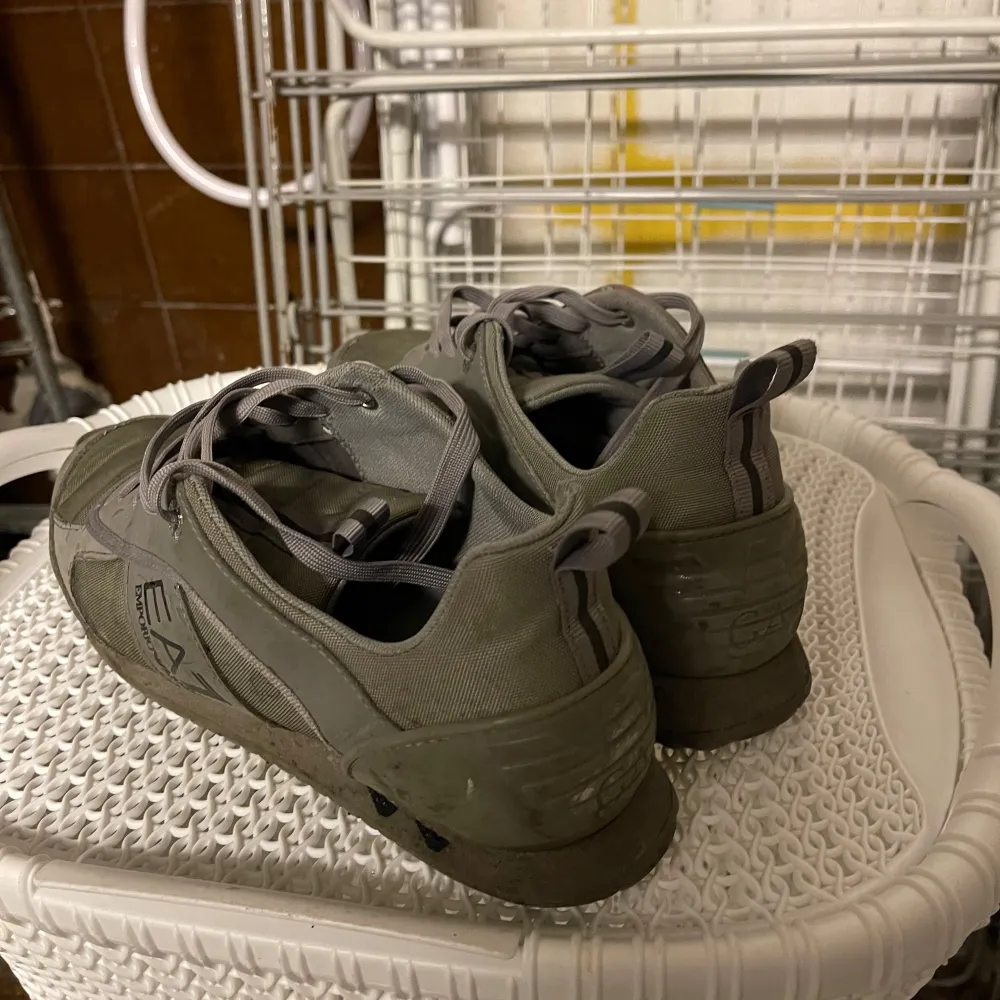 Säljer ett par grå sneakers från EA7 i bra skick. Skorna har en stilren design med snörning och är perfekta för vardagsbruk. De är tillverkade i syntetmaterial och har en bekväm passform. Perfekta för höst och vår! Dom har storlek 42.. Kengät.
