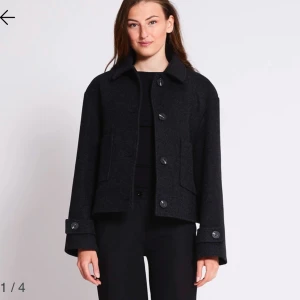 Svart kappa med knappar - Snygg svart kappa i mycket bra skick. Den har en klassisk design med stora knappar framtill och långa ärmar. Perfekt för höst och vinter, och passar både till vardags och fest. Storleken är dam M och den är gjord i ett bekvämt material som håller dig varm.