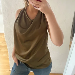 Olivgrön ärmlös topp från BYIC - Säljer en snygg olivgrön ärmlös topp från BYIC i storlek M. Väldigt bra skick och passar perfekt till fest. Perfekt att matcha med jeans eller kjol!