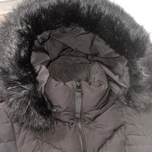 Svart dunjacka med fuskpäls - Säljer en svart dunjacka från A. S. Ivy i mycket bra skick. Jackan har en mysig huva med fuskpäls och dragkedja framtill. Perfekt för kalla vinterdagar! Den är quiltad och har praktiska fickor med dragkedjor.