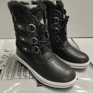 Svarta vinterstövlar från Polar - Snygga och varma svarta vinterstövlar från Polar med snörning och pälsdetaljer. Perfekta för kalla vinterdagar med en robust sula för bra grepp. Stövlarna har en stilren design med flera spännen och är gjorda i syntetmaterial.