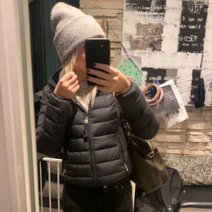 Dunjacka från Parajumpers - Snygg och varm svart dunjacka från Parajumpers. Jackan har en dragkedja framtill och en praktisk huva. Perfekt för kyliga höst- och vinterdagar. Den är i mycket bra skick! Den är i S men skulle säga den passar XS/XSS.