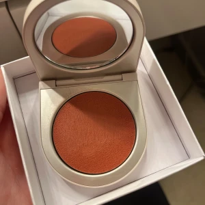 Krämrouge från Rose Inc fören Foxglove - Säljer ett superfint krämrouge från Rose Inc i en varm terrakottafärg. Kommer i en stilren, beige förpackning med inbyggd spegel, perfekt för touch-ups under dagen. Rouget ger en naturlig och fräsch look. Perfekt för både vardag och fest! Testad på handen som syns😊