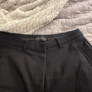 Svarta kostymbyxor från Stockh LM - Säljer ett par svarta kostymbyxor från Stockh LM. De har en klassisk design med hög midja och raka ben. 