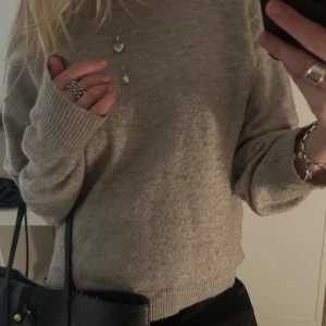 Beige stickad tröja - Säljer en supermysig beige stickad tröja i normal passform. Perfekt för höst och vinter med långa ärmar och ribbade muddar. Den är i bra skick och passar till alla tillfällen. Perfekt att mysa i eller styla upp med smycken och accessoarer 💗