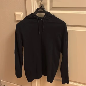 Svart hoodie från EDC - Säljer en stilren svart hoodie från EDC. Den är i bra skick men har liten missfärgning på varan men annars är den perfekt och den är perfekt för både höst och vinter. Tröjan har en klassisk design med långa ärmar och en bekväm huva med dragsko. Passar perfekt för en avslappnad stil eller som lager under en jacka. Priset kan förhandlas.
