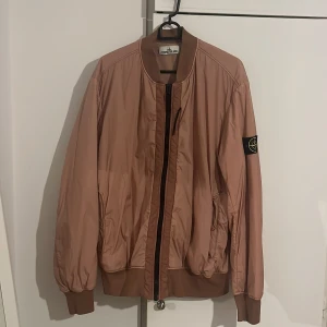 Beige bomberjacka från Stone Island - Beige bomberjacka från stoneisland, den är väldigt varm, kan även funka som vinterjacka, användes förra vintern ett fåtal gånger men passar inte längre.