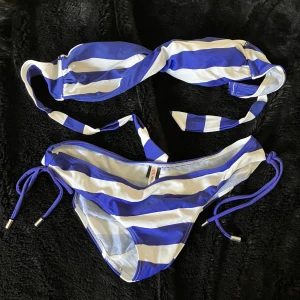 Blåvit randig bikini - Säljer en superfin blåvit randig bikini från Wonderland. Den har knytband på sidorna och har inget knyte över axlarna. 