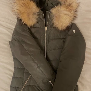 Rockandblue vinterjacka  - Militärgrön rockandblue vinterjacka med fina gulddetaljer. Pälsen är äkta och fluffig fortfarande med en kall jättefin färg. Den sitter väldigt smickrande på. 