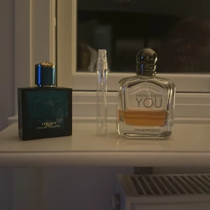  Versace Eros  och Emporio Armani ”10 ML” - Säljer två parfymer: Versace Eau de Toilette i en snygg blå flaska med guldlock och Emporio Armani Stronger With You i en elegant genomskinlig flaska med svart lock. Perfekta för både vardag och fest! 💙✨