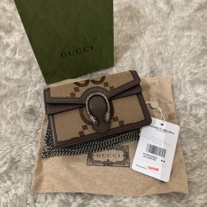 Gucci Dionysus  - Säljer en ”Gucci Dionysus” crossbody plånbok . Den har ett klassiskt GG-mönster och en stilren design med en metallspänne framtill. Perfekt för att hålla dina kort och kontanter organiserade. Allt i bilden ingår!