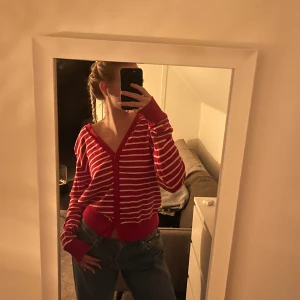 Röd och vit randig kofta - Säljer en superfin röd och vit randig kofta med v-ringning. Den är perfekt för både höst och vår och har en skön, loose passform. Koftan är i bra skick och passar perfekt till jeans för en avslappnad look. Perfekt för mysiga dagar! 🌟