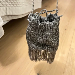 Glittrig axelväska med fransar - Festlig väska, perfekt till nyår. Oanvänd