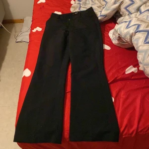 Svarta byxor från Bik Bok - Säljer ett par svarta kostymbyxor från Bik Bok i storlek 36. De har en klassisk design med hög midja och en rak, vid passform. Perfekta för både vardag och fest! 🖤 är du runt 165-170 så kommer den bli lågmidjad för dig.