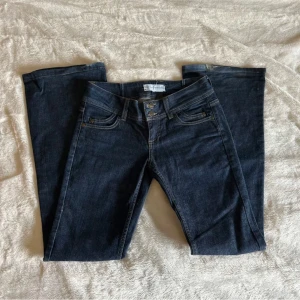 Mörkblå jeans - Säljer ett par snygga mörkblå jeans i bra skick. De har en klassisk femficksdesign med knappar och dragkedja fram. Perfekta för både vardag och fest! 🕺