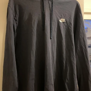 Marinblå hoodie från Nike - Säljer en marinblå hoodie från Nike i bra skick. Den har en klassisk design med en liten Nike-logga på bröstet och en justerbar huva med dragsko. Perfekt för både träning och vardag. Skön och enkel att matcha med det mesta! Storlek XL 