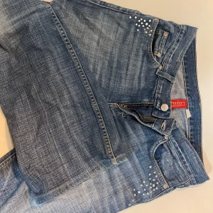 Blå bootcut jeans med pärldetaljer - Snygga blå bootcut jeans från H&m pärldetaljer vid fickorna. en bekväm passform. Perfekta för en avslappnad men ändå stilren look. Passar både till vardags och fest! Passar helt okej på mig vid längden och är 169cm! Säljer dessa som de ej kommer till användning 