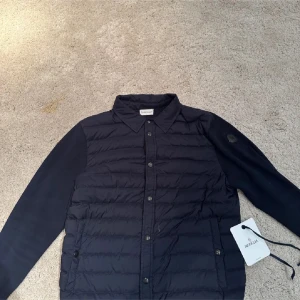 Svart dunjacka från Moncler - Säljer en snygg svart dunjacka från Moncler i mycket bra skick storlek M/S. Jackan har en quiltad design med långa ärmar och knappar framtill. Perfekt för höst och vår, och den är både stilren och varm. Passar perfekt för dig som vill ha en lätt men ändå varm jacka. Den har några flaws där av priset. Nu pris ca 7500 mitt pris 4000 