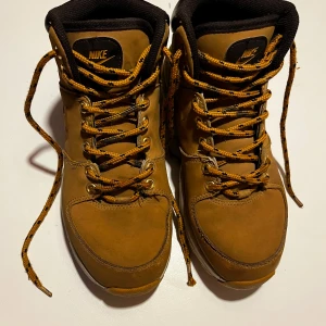 Nike Manoa kängor stl 39 EUR - Säljer ett par robusta ljusbruna Nike boots i Nubuck-skinn med snygg snörning. Perfekta för höst och vinter med en slitstark sula och bekväm passform. 