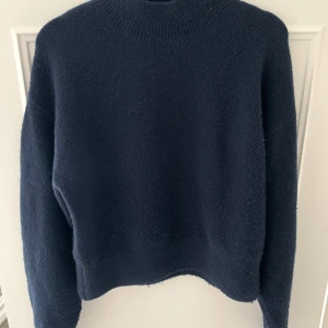 Mörkblå tjocktröja  - Säljer en supermysig mörkblå tröja som är perfekt för kyliga dagar från &other stories. Den har en normal passform och långa ärmar, vilket gör den idealisk för både höst och vinter. Tröjan är i bra skick och redo för en ny ägare. Perfekt för att mysa hemma eller ta en promenad i parken!